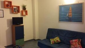 sala de estar con sofá azul y TV en mini Residence Samarcanda appartamenti en Porto Cesareo