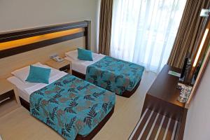a hotel room with two beds and a table at Cimen Hotel in Alanya