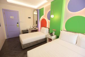 Habitación de hotel con 2 camas y una pared colorida. en M.Y. Hotel en Dumaguete