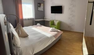 ein Schlafzimmer mit einem Bett und einem grünen Stuhl in der Unterkunft Hotel Bartenwetzer vormals Ellenberger in Melsungen