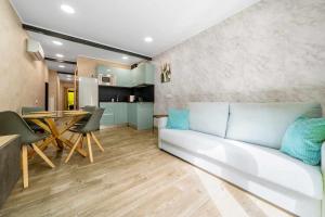 uma sala de estar com um sofá branco e uma mesa em Apartments Lilia Reus em Reus