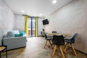 un soggiorno con tavolo, sedie e divano di Apartments Lilia Reus a Reus