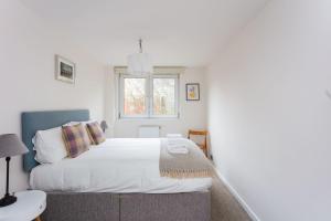 a bedroom with a white bed with a window at Spacious Central 3 Bedroom Apartment in Old Street in London