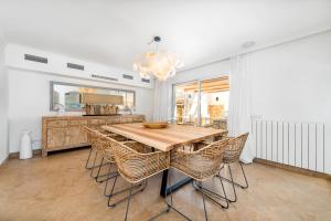 jadalnia z drewnianym stołem i krzesłami w obiekcie Luxury Villa with panoramic sea views w mieście Sol de Mallorca