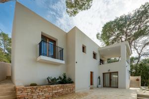 a white house with a staircase and a balcony at Casa Juliarina in Sant Josep de sa Talaia