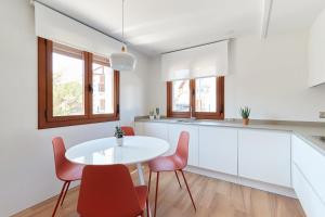 cocina con mesa blanca y sillas rojas en Leku Eder, casa en Lekunberri, en Lekunberri