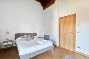 1 dormitorio con 1 cama y puerta de madera en Leku Eder, casa en Lekunberri, en Lekunberri