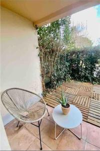 un patio con una silla, una mesa y una planta en Le Ludz Blagnac en Blagnac