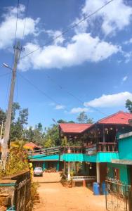 ChikmagalurREST POINT HOMESTAY的蓝色建筑,有红色屋顶