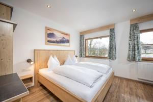 een slaapkamer met een groot wit bed met witte lakens bij Tauerncamping Apartment in Radstadt
