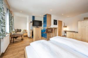 ein Hotelzimmer mit einem Bett, einem Schreibtisch und einem TV in der Unterkunft Tauerncamping Apartment in Radstadt