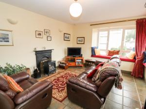 a living room with two leather couches and a fireplace at Barnstead in Pooley Bridge