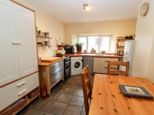 uma cozinha com uma mesa de madeira e uma mesa e uma sala de jantar em Barnstead em Pooley Bridge