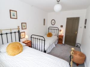 a bedroom with two beds and two tables with lamps at Barnstead in Pooley Bridge