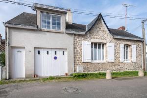 Biały dom z dwoma białymi drzwiami garażowymi w obiekcie Maison a 300 m du port du Croisic! w mieście Le Croisic
