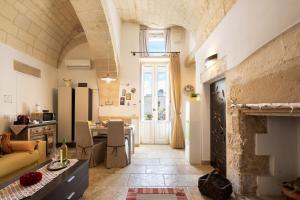una cucina e un soggiorno con un tavolo e un divano di Suite Psema a Muro Leccese
