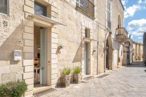un vicolo in un vecchio edificio in pietra con una persona in lontananza di Suite Psema a Muro Leccese