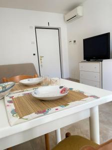 een witte tafel met twee platen erop bij PRESTIGE - Premium Villas in Giulianova