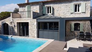 穆然的住宿－Mougins limite Cannes Magnifique Mas vue sur le village historique de Mougins，房屋前有游泳池的房子