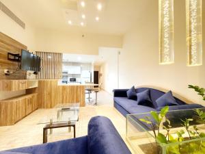sala de estar con sofá azul y mesa en Zenith Smart Vacation Homes Rental - ZENITH TOWER A1 en Dubái