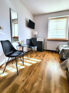 a living room with two chairs and a table at Kozi Lasek in Koluszki