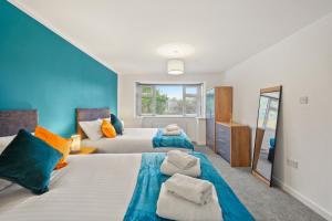 sypialnia z 2 łóżkami i lustrem w obiekcie 2BR Barnet Gem with Front Garden w mieście Barnet