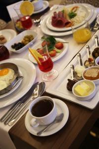 een tafel met borden ontbijtproducten en een kopje koffie bij Morrian Hotel in Inegol