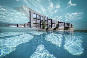 a large swimming pool in a building with windows at Cresta Palace Celerina in Celerina