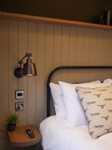 ein Schlafzimmer mit einem Bett mit einer Lampe und einem Tisch in der Unterkunft Waggon and Horses, Eaton, Congleton in Eaton