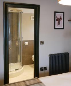 ein Bad mit einer Dusche und einem WC in einem Zimmer in der Unterkunft Waggon and Horses, Eaton, Congleton in Eaton