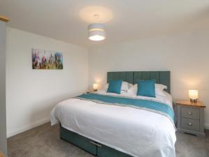 a bedroom with a large bed with blue pillows at Dove Meadows House in Buxton +39 photos