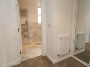 a bathroom with a shower and a walk in closet at Dove Meadows House in Buxton