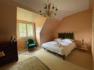 een slaapkamer met een bed en een groene stoel bij Sejour pour 6 personnes a Arradon in Arradon