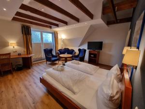 a bedroom with a large bed and a table and chairs at Hotel Osterkrug in Husum