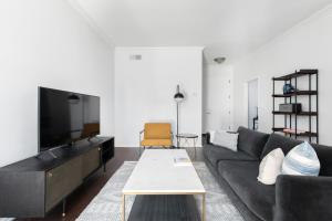 a living room with a black couch and a tv at Beverly Hills 1BR nr Century City The Grove LAX-369 in Los Angeles