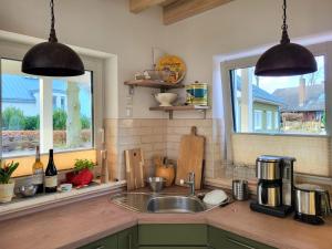 a kitchen with a sink and two windows at Haus Theda in Fockbek