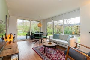a living room with a couch and a table at Welcome in - Vakantiehuis - Inlaag 31, Wolphaartsdijk in Wolphaartsdijk