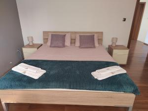 ein Schlafzimmer mit einem großen Bett mit grüner Bettwäsche und Kissen in der Unterkunft Manuela in Ližnjan