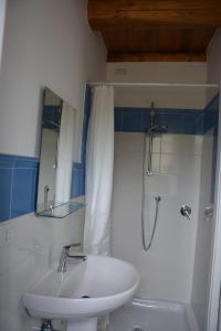 uma casa de banho branca com um lavatório e um chuveiro em Casale Dionisia, Santa Maria di Castellabate, Appartamento Iris em Castellabate