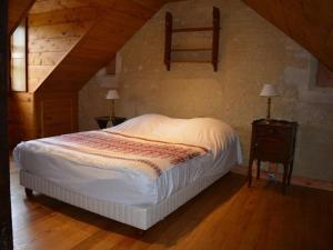 Manoir de Danigny في Saint-Martin-des-Entrées: غرفة نوم بسرير وطاولتين ونافذة