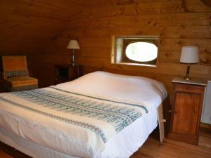 Dormitorio con cama y ventana en una cabaña en Manoir de Danigny en Saint-Martin-des-Entrées