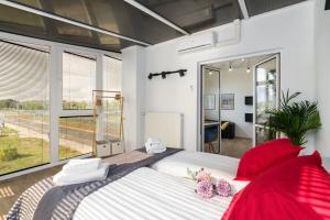1 dormitorio con 1 cama grande con almohadas rojas en Apartamenty Ziębicka 2 en Poznan