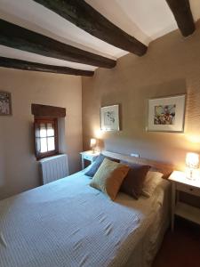 una camera con un grande letto in una stanza con travi di Pla del Castell I a Albarca