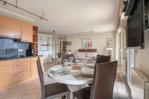 cocina y comedor con mesa y sillas en Appartement face mer pour 4 personnes, en Pornic