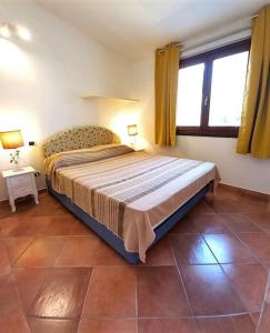 a bedroom with a large bed with two windows at A Casa di Viola o Villa Violetta in Marina di Portisco