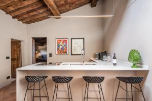 een keuken met een groot eiland met barkrukken bij La Porticina in Montalcino