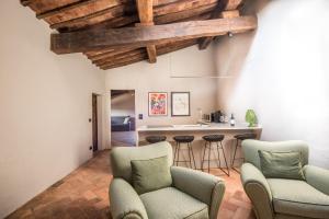 een woonkamer met 2 stoelen en een keuken bij La Porticina in Montalcino