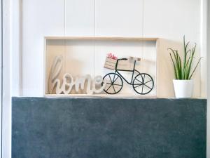 a sign that says home with a bike on a shelf at Soul House in Sens