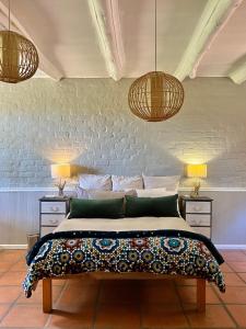 a bedroom with a bed with two lamps and two tables at Rivers Own Guest Lodge in Breerivier