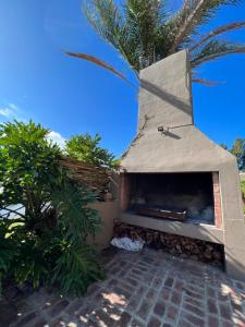 a pizza oven sitting next to a palm tree at Rivers Own Guest Lodge in Breërivier